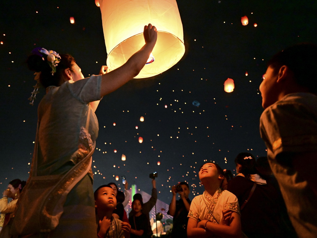 4月13日晚，人們在西雙版納傣族自治州景洪市瀾滄江畔放飛孔明燈。