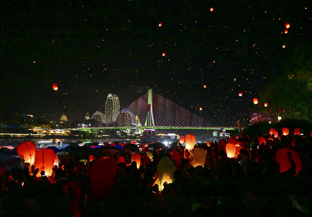 4月13日晚，人們在西雙版納傣族自治州景洪市瀾滄江畔放飛孔明燈。