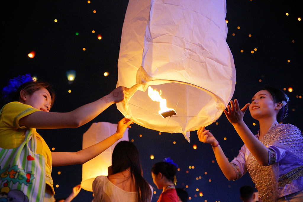 4月13日晚，人們在西雙版納傣族自治州景洪市瀾滄江畔放飛孔明燈。