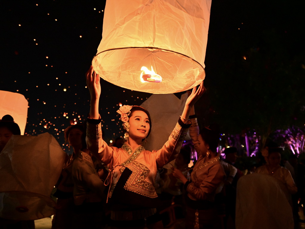 4月13日晚，人們在西雙版納傣族自治州景洪市瀾滄江畔放飛孔明燈。