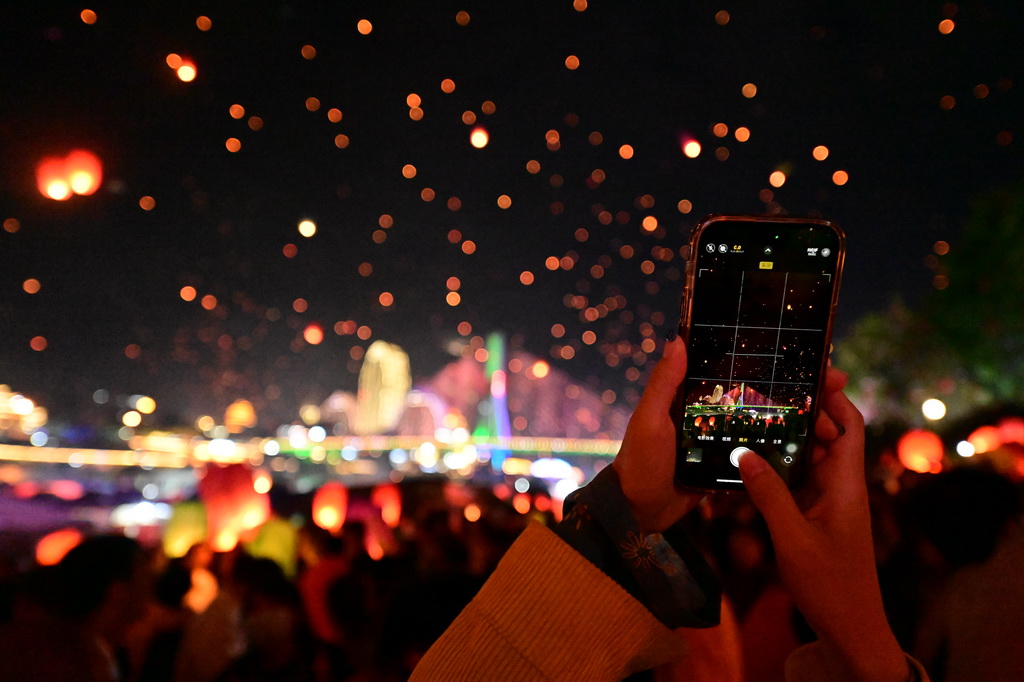 4月13日晚，人們在西雙版納傣族自治州景洪市瀾滄江畔放飛孔明燈。