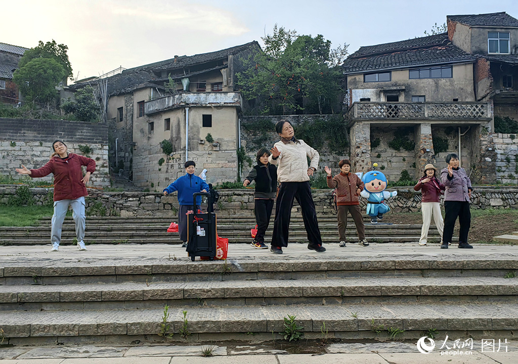4月12日，安徽蕪湖紅楊西河古鎮渡口廣場上，悠揚的廣場舞旋律回蕩在青瓦白墻間。當地村民踩著輕快的節奏起舞時，過往游客熱情地融入隊伍，與村民們并肩起舞，構成一幅古鎮人文與煙火氣息交融的生動圖景。人民網記者 單芳攝