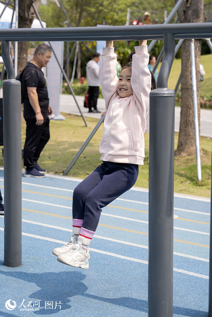 4月2日，廣東省深圳市福田區筆架山公園內，一名小女孩歡快地懸掛于橫桿。人民網 李語攝