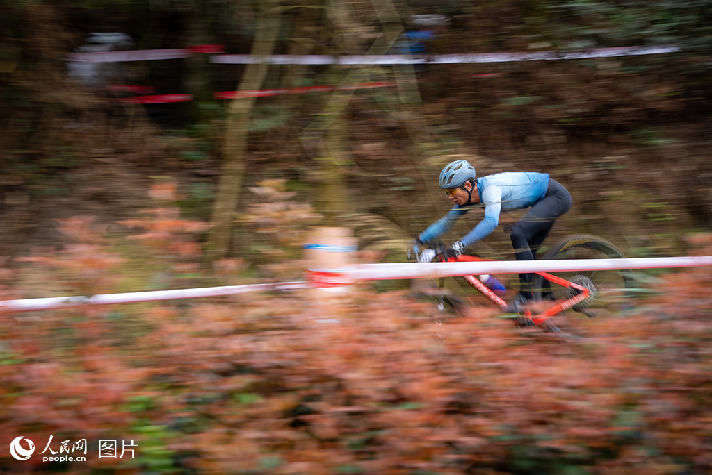 3月30日，2025年第九屆“多彩貴州”自行車聯賽（福泉站）山地自行車越野賽在貴州省黔南州福泉市雙谷生態體育公園開賽，圖為參賽運動員穿過叢林賽道。人民網記者 涂敏攝