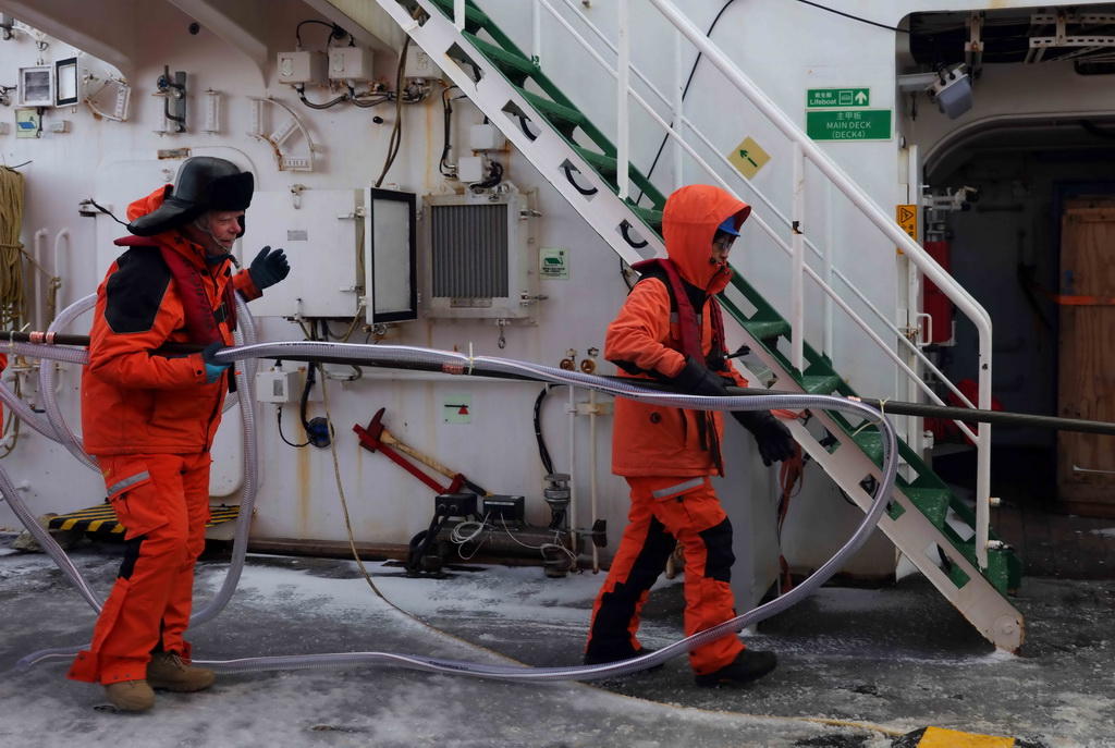 3月29日，中外科考隊員在“雪龍2”號上合作準備實驗器材。