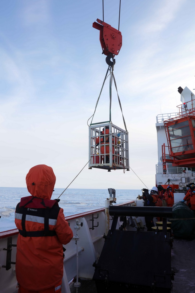 3月29日，科考隊員乘坐吊籠，準備布放浪-冰浮標和海冰漂流浮標。