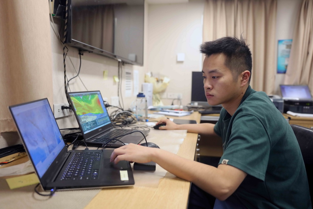 4月13日，“雪龍2”號隨船氣象員徐曉武在根據氣象資料研判未來天氣形勢。