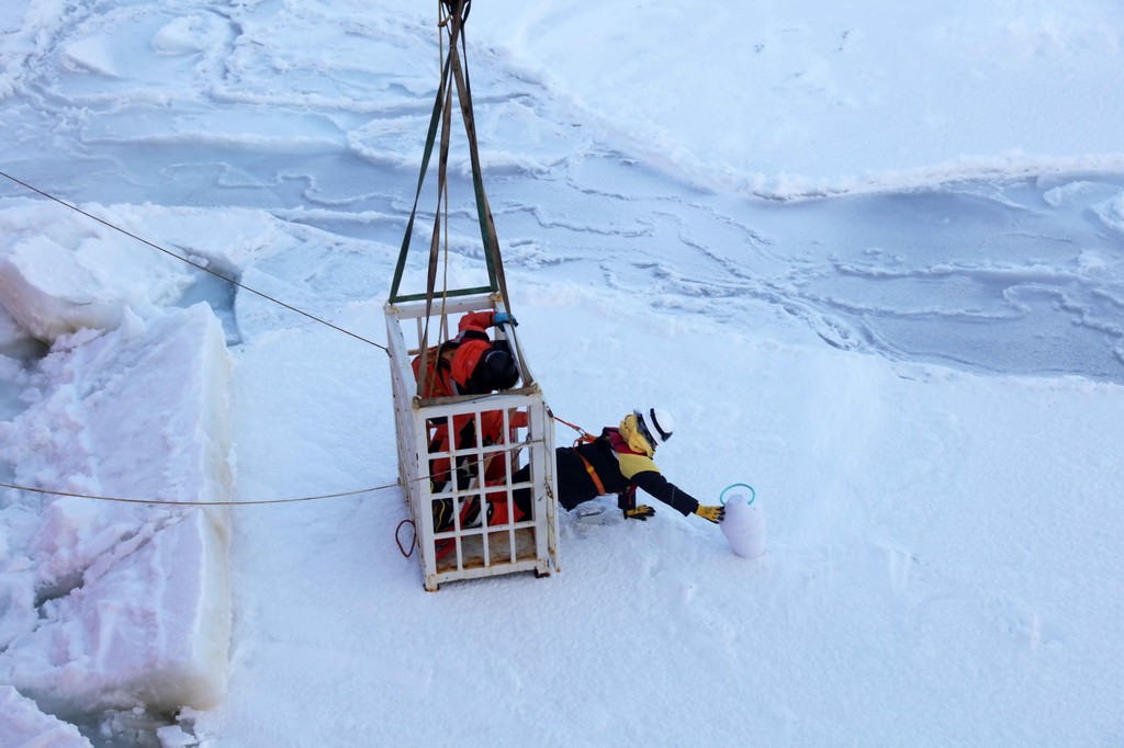 3月29日，科考隊員乘吊籠到冰面布放浪-冰浮標和海冰漂流浮標。