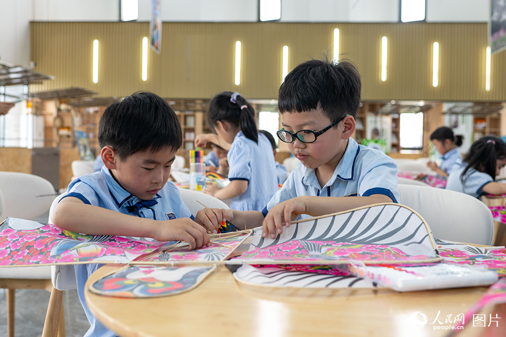 2025年4月17日，在浙江省嘉興市余新鎮長秦村，一群小朋友正在親手制作紙鳶，體驗非遺手工帶來的樂趣。