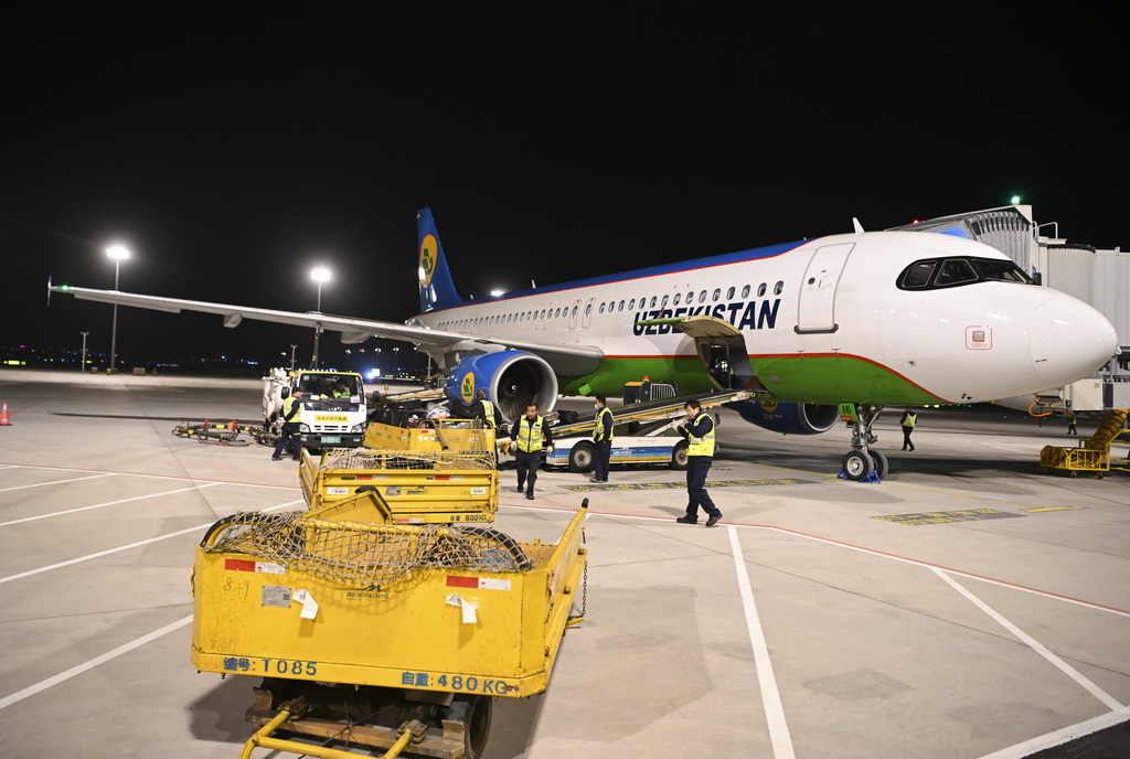 4月19日，由費爾干納飛往烏魯木齊的HY571航班降落在烏魯木齊天山國際機場，工作人員在搬運行李。