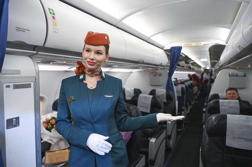 4月19日，乘務員在由烏魯木齊飛往費爾干納的HY572航班上引導旅客登機。
