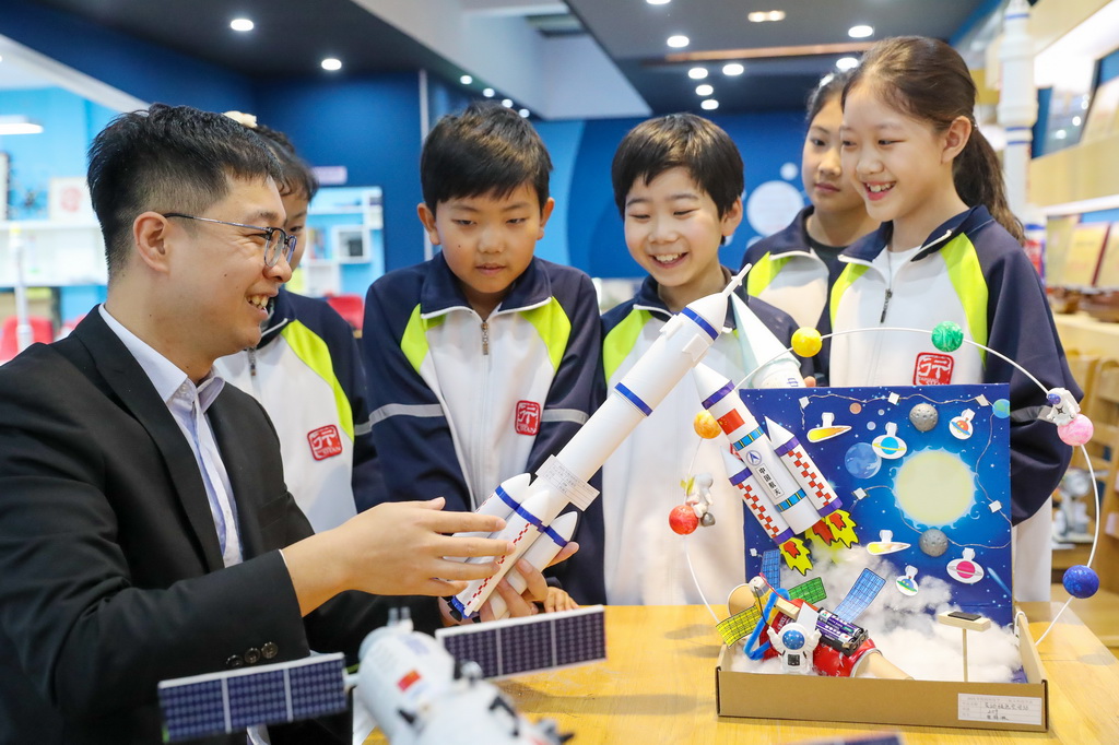4月24日，在山東省青島市西海岸新區太行山路小學，老師給同學們講解航天知識。新華社發（張進剛 攝）