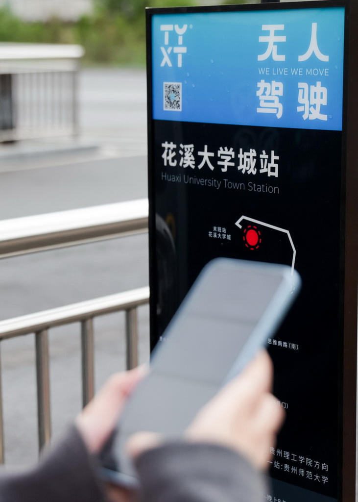 4月24日，在貴陽市花溪大學城公交車站，前來參與體驗活動的市民在掃碼試乘無人駕駛公交車。新華社發（袁福洪攝）