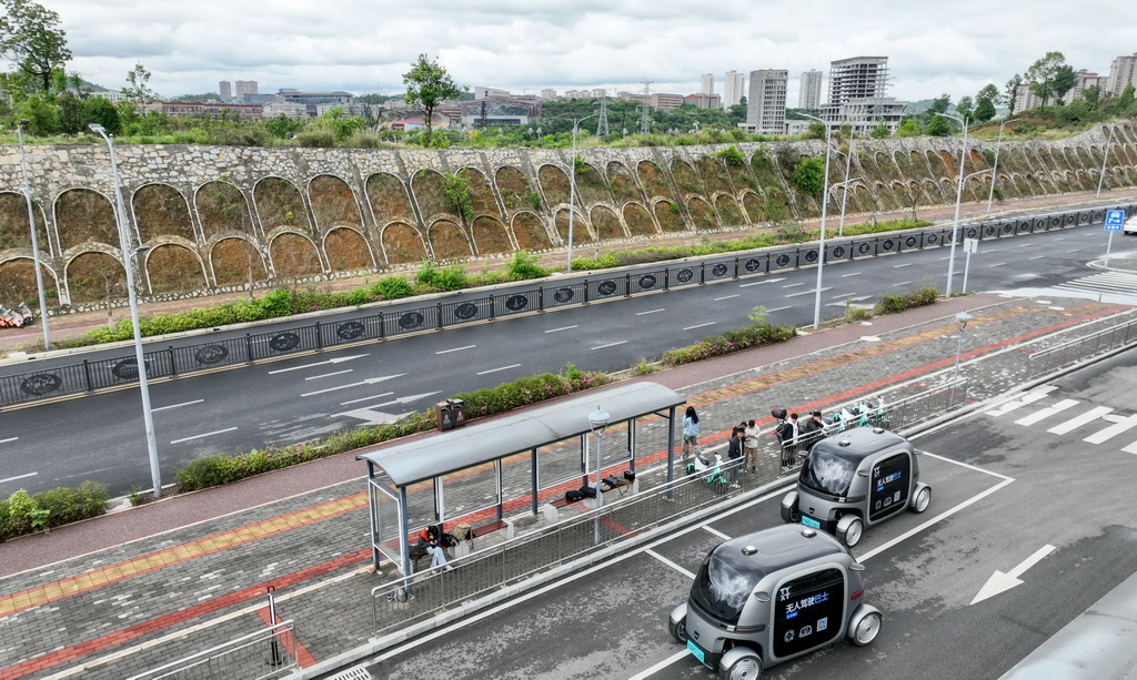 4月24日，參與體驗活動的市民在貴陽市花溪大學城公交車站試乘無人駕駛公交車（無人機照片）。新華社記者 劉續 攝