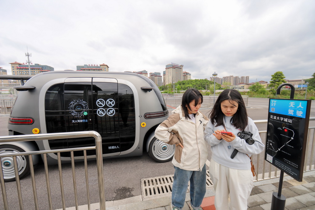 4月24日，在貴陽市花溪大學城公交車站，前來參與體驗活動的市民在掃碼試乘無人駕駛公交車。新華社發（袁福洪攝）