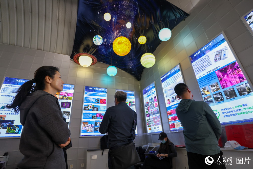 觀眾在觀看“月宮一號”科普基地的展板介紹。