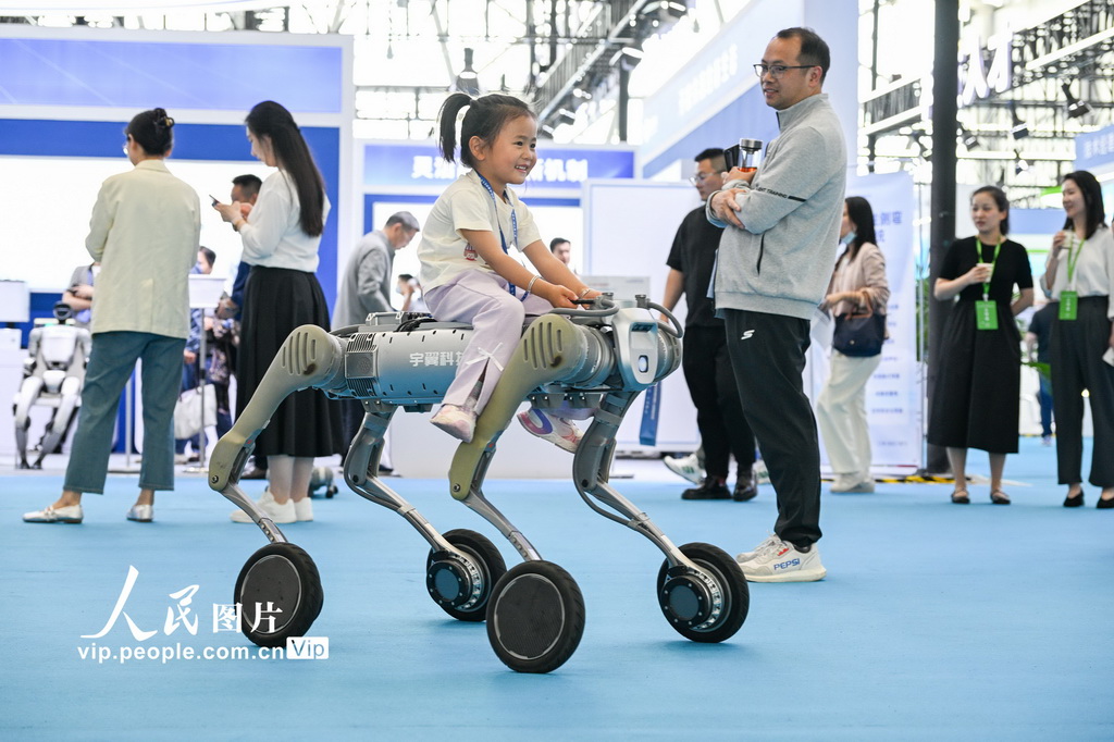 4月26日，小朋友在第三屆中國（安徽）科技創新成果轉化交易會上體驗一款機器狗。