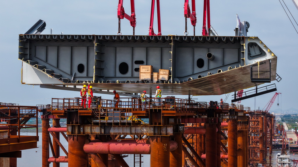 4月29日，施工人員在萬龍大橋鋼梁支架上接收首節鋼箱梁（無人機照片）。