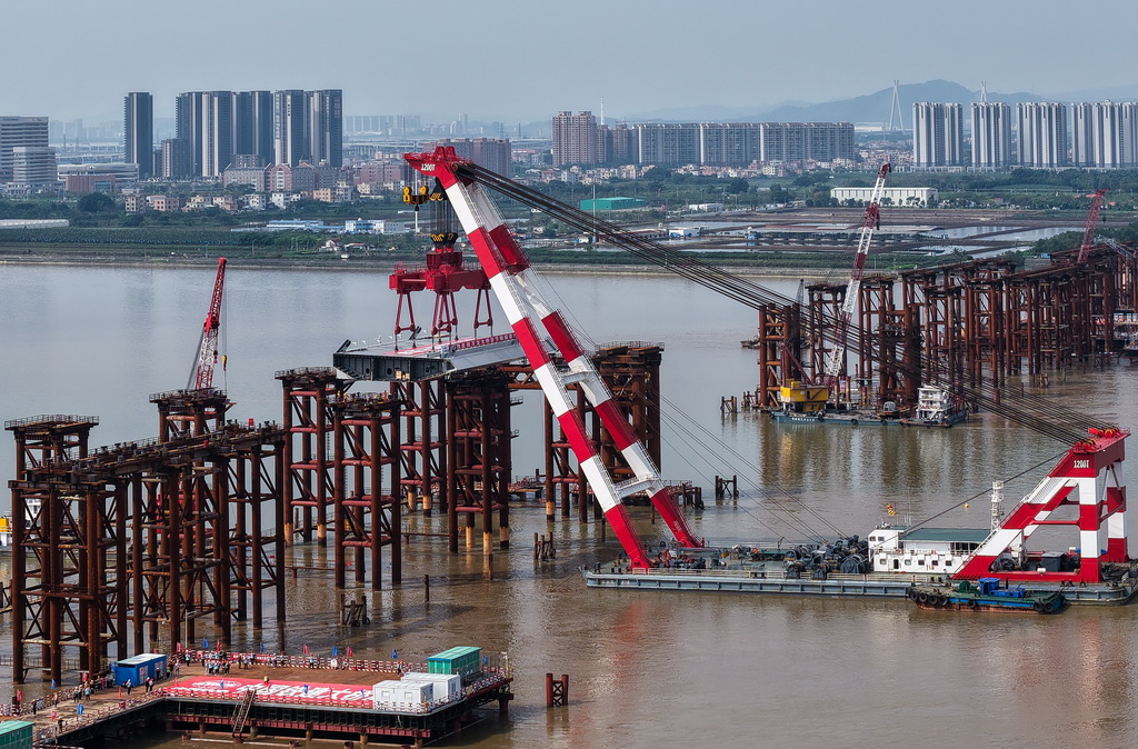 4月29日，1200噸大型浮吊將重達606噸的首節鋼箱梁吊裝架設到萬龍大橋鋼梁支架上（無人機照片）。