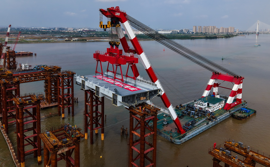 4月29日，1200噸大型浮吊將重達606噸的首節鋼箱梁精準架設在萬龍大橋鋼梁支架上（無人機照片）。
