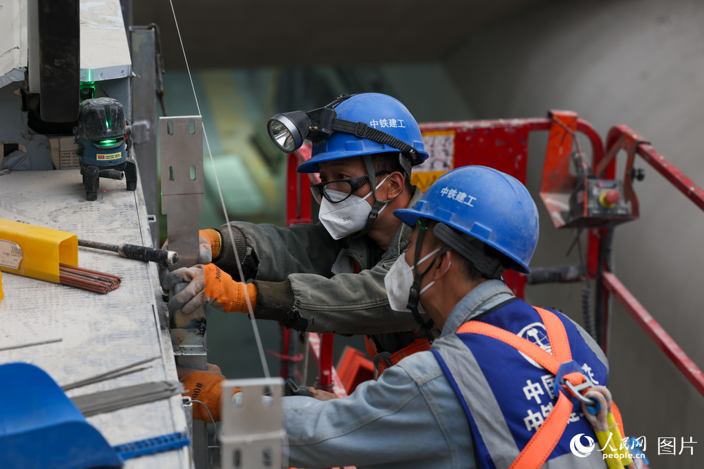 工人在施工現場安裝扶梯。