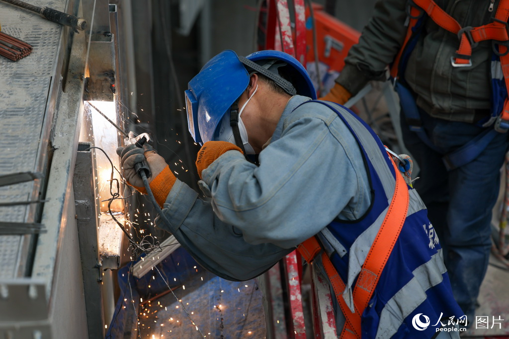 工人在施工現場安裝扶梯。