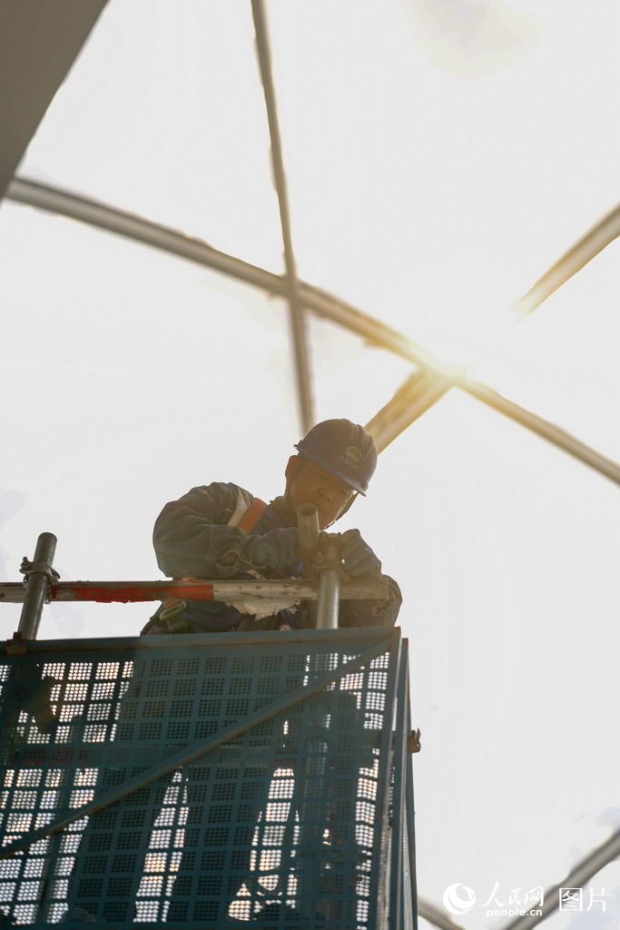 工人在施工現場加固腳手架。