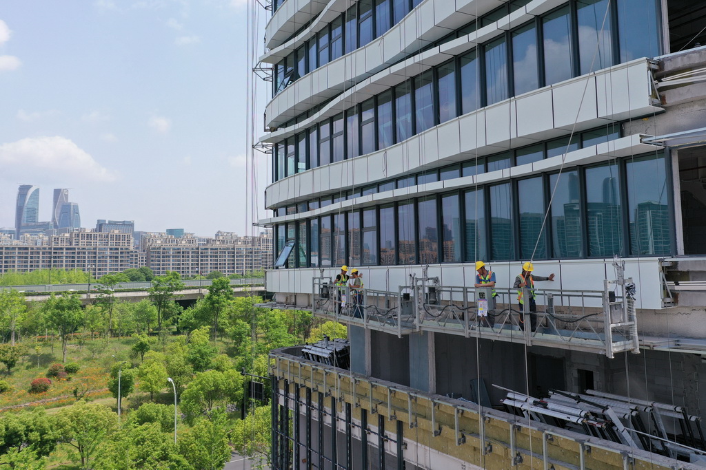 5月1日，中建四局建設者在浙江大學醫學院附屬婦產科醫院錢江院區二期項目現場進行玻璃幕墻安裝作業（無人機照片）。新華社記者 黃宗治 攝