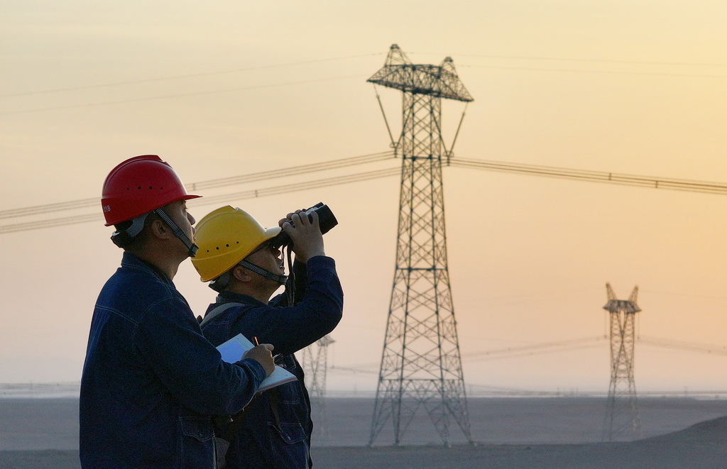 5月1日，在新疆哈密市雅滿蘇鎮附近的±1100千伏昌吉-古泉特高壓直流輸電線路旁，新疆送變電公司員工對線路開展巡視（無人機照片）。新華社發（張利民 攝）