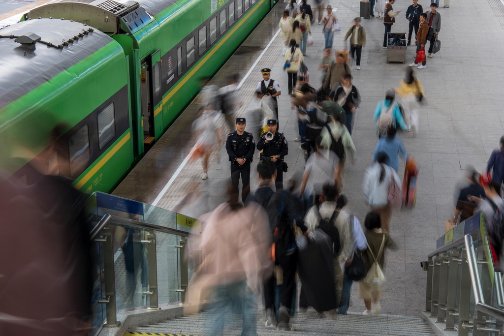 5月1日，烏魯木齊鐵路公安處烏魯木齊站派出所民警在站臺引導旅客安全乘車。新華社發（葉帥 攝）