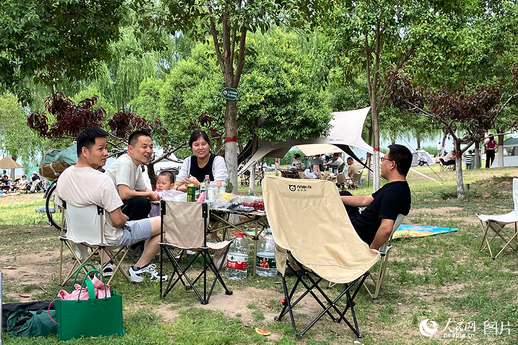 2025年5月2日，陜西省西安市西安湖，一群游客在湖邊露營聚餐。人民網 吳德鋒攝