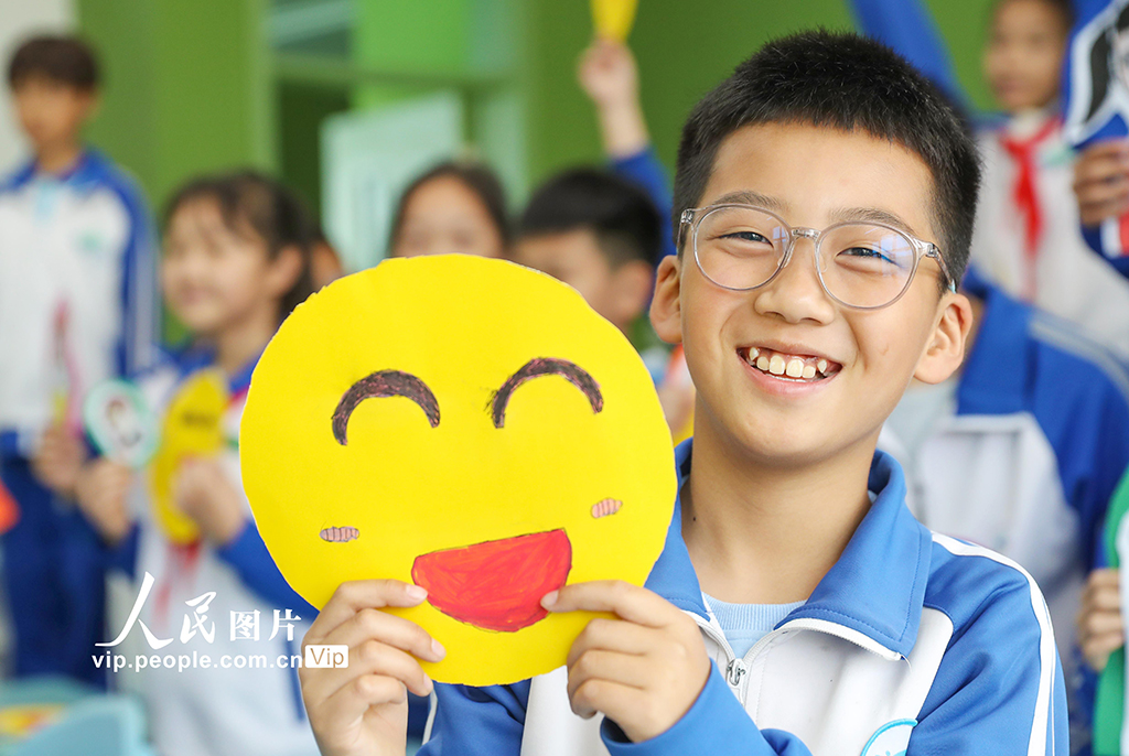 2025年5月8日，山東青島西海岸新區井岡山路小學的學生們，相互展示自己手繪的“笑臉”。張進剛攝（人民圖片網）