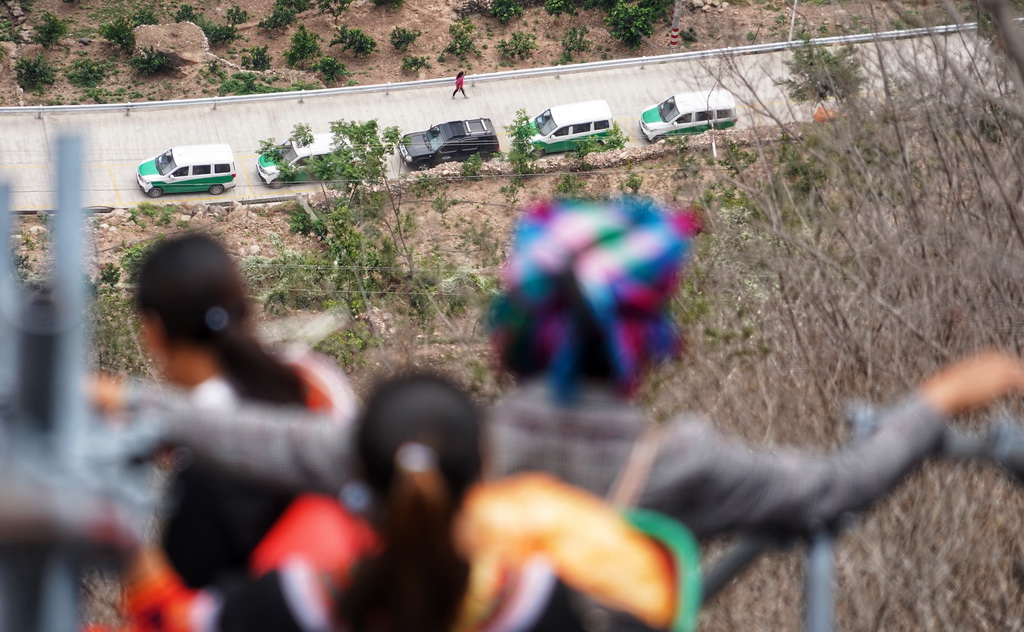 四川省昭覺縣阿土列爾村（懸崖村舊稱）村民沿著懸崖鋼梯下山，準備搬家前往新家園，遠處山腳下已停放好等待運送他們的車輛（2020年5月13日攝）。新華社記者 王曦 攝