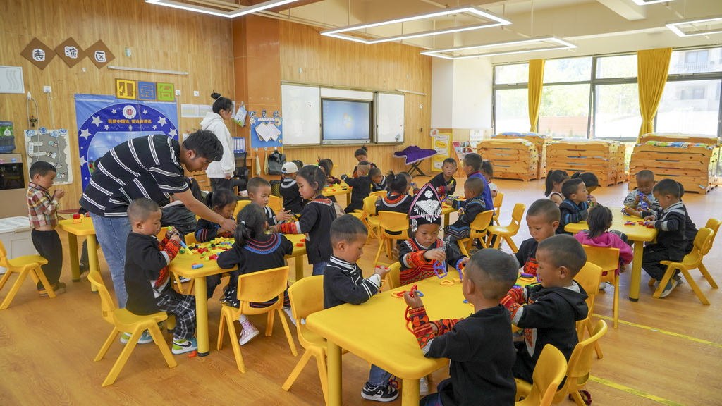 四川省昭覺縣昭美社區幼兒園小朋友在老師的指導下玩游戲（2025年4月21日攝）。新華社記者 尹恒 攝