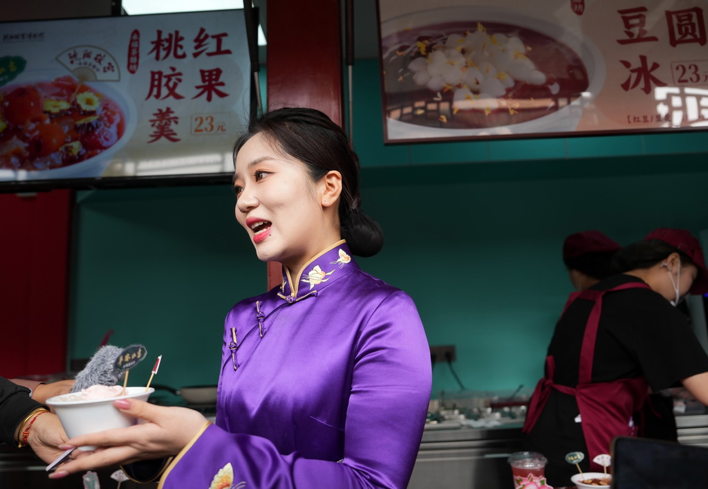 2024年5月10日，沈陽故宮博物院講解員為游客介紹美食文創產品。新華社記者 李鋼 攝