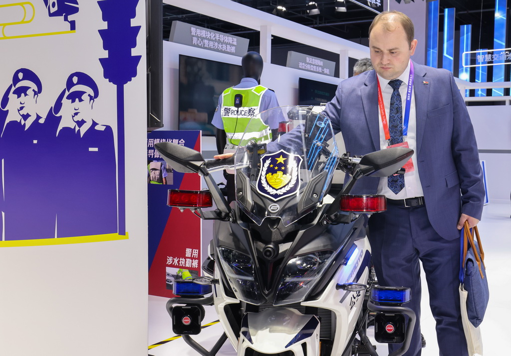 5月14日，在第十二屆中國國際警用裝備博覽會交通管理裝備展區，外國嘉賓在觀看警用摩托車。新華社記者 殷剛 攝