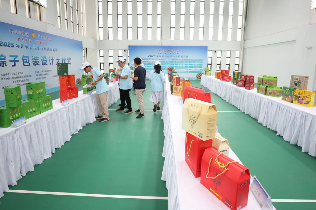 5月16日，評委在海南定安縣2025年粽子行業技能競賽中給粽子包裝評分。