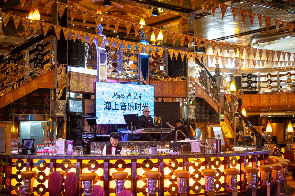 5月27日，在國際郵輪“愛達·地中?！碧柹?，工作人員為游客演出。