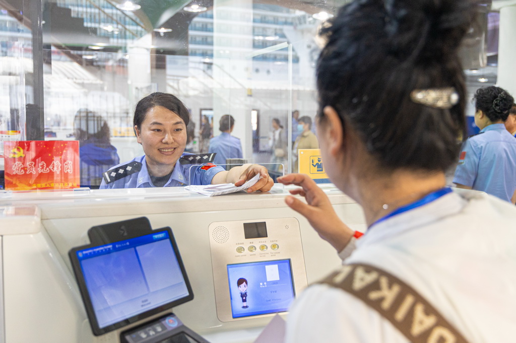 5月27日，大連港國際郵輪中心邊檢民警為登輪游客辦理出境手續。