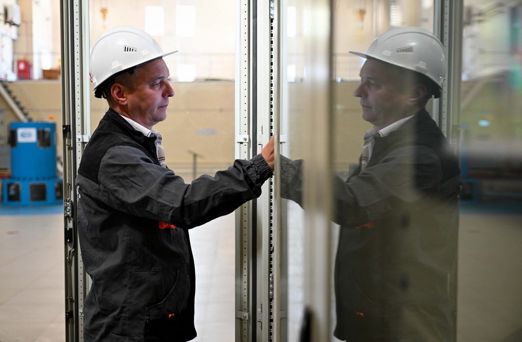 5月8日，在哈薩克斯坦東哈州的圖爾古孫水電站，水電站現場調度員涅波米亞什奇在發電機層巡檢水輪發電機組運行狀態。新華社記者 李任滋 攝