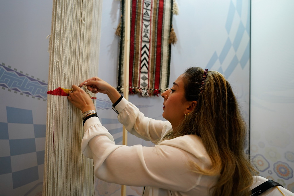 5月28日，在成都國際非遺節“魅力非遺·國際大展”現場，科威特手藝人編織羊毛紡織品。