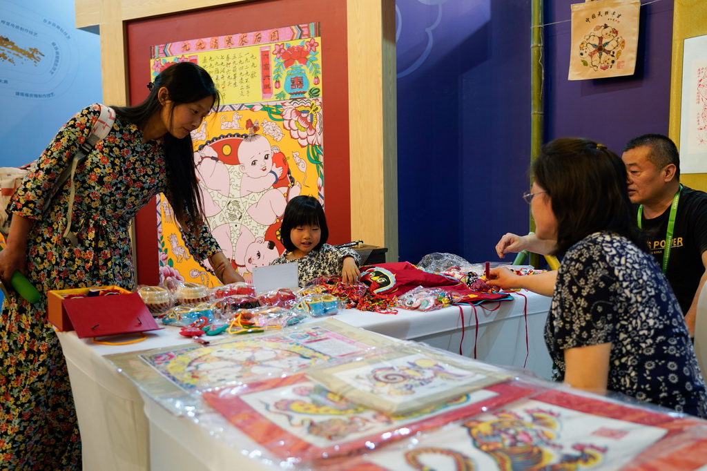 5月28日，在成都國際非遺節“魅力非遺·國際大展”現場，小朋友觀看虎頭鞋。