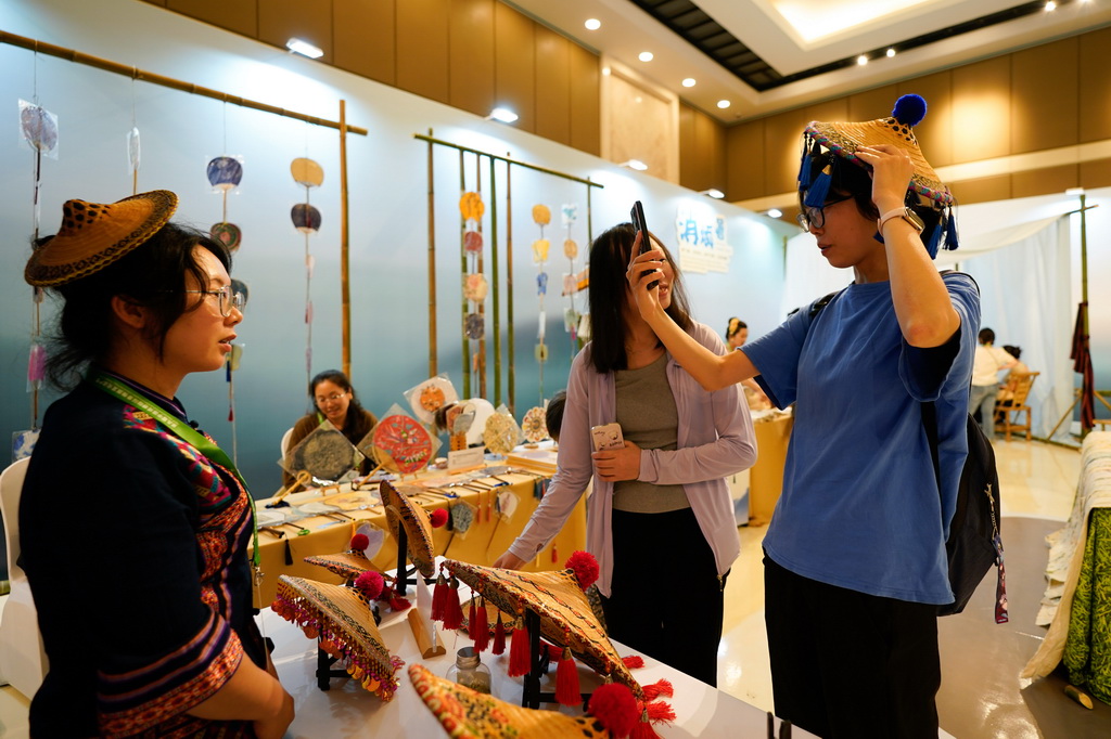 5月28日，在成都國際非遺節“魅力非遺·國際大展”現場，參觀者體驗毛南族花竹帽。