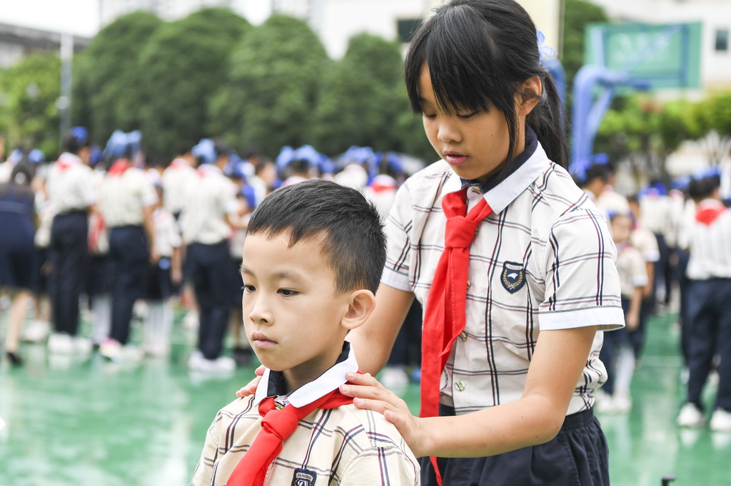 5月30日，在廣西南寧市濱湖路小學教育集團濱湖校區少先隊員入隊儀式上，高年級學生為新隊員戴紅領巾。