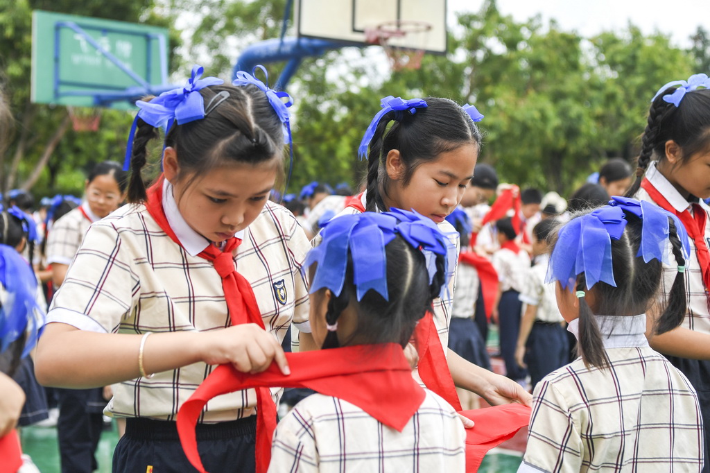 5月30日，在廣西南寧市濱湖路小學教育集團濱湖校區少先隊員入隊儀式上，高年級學生為新隊員戴紅領巾。