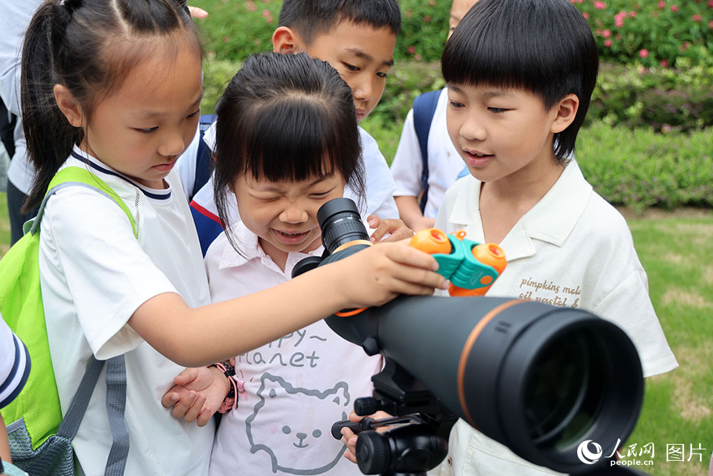2025年5月25日，在福建省廈門市五緣灣濕地公園中，孩子們用專業望遠鏡體驗戶外觀鳥。人民網記者 陳博攝