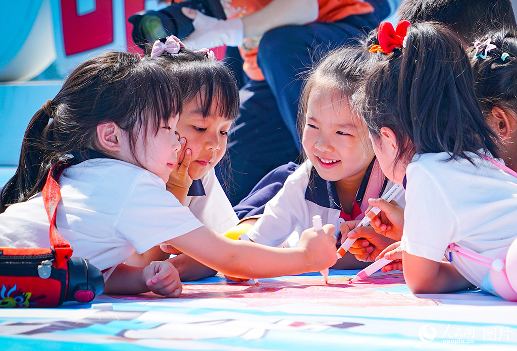 2025年5月27日，在黑龍江省哈爾濱極地公園，百名兒童在巨幅畫布上揮灑童心，用五彩筆觸描繪心目中的美麗世界。人民網記者 蘇靖剛攝