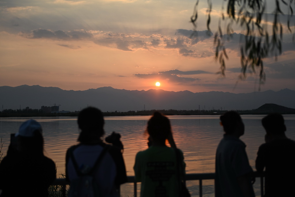 游客在寧夏銀川覽山公園觀賞賀蘭山日落（2024年7月10日攝）。新華社記者 毛竹 攝