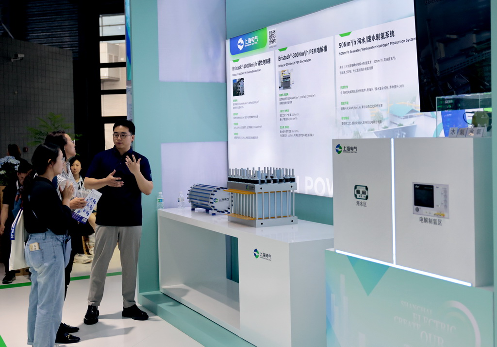6月5日，工作人員（右）在向參觀者介紹電解槽制氫設備。