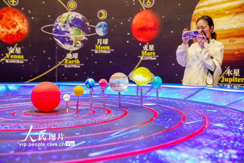 6月7日，游客在甘肅省武威市民勤縣摘星小鎮的星空探索區學習天文知識。